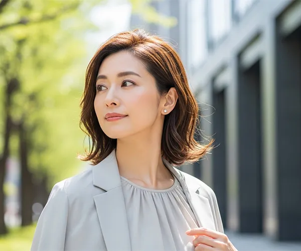 ピアスを着けて微笑む40代女性｜理想の自分を表現する大人のジュエリー選び